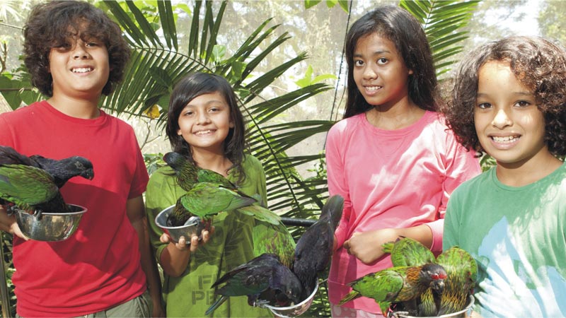 Anak-anak memegang Nuri Hijau di Taman Burung.