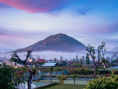 Pemandangan indah Gunung Batur di Kintamani dengan kabut pagi dan desa di kaki gunung.