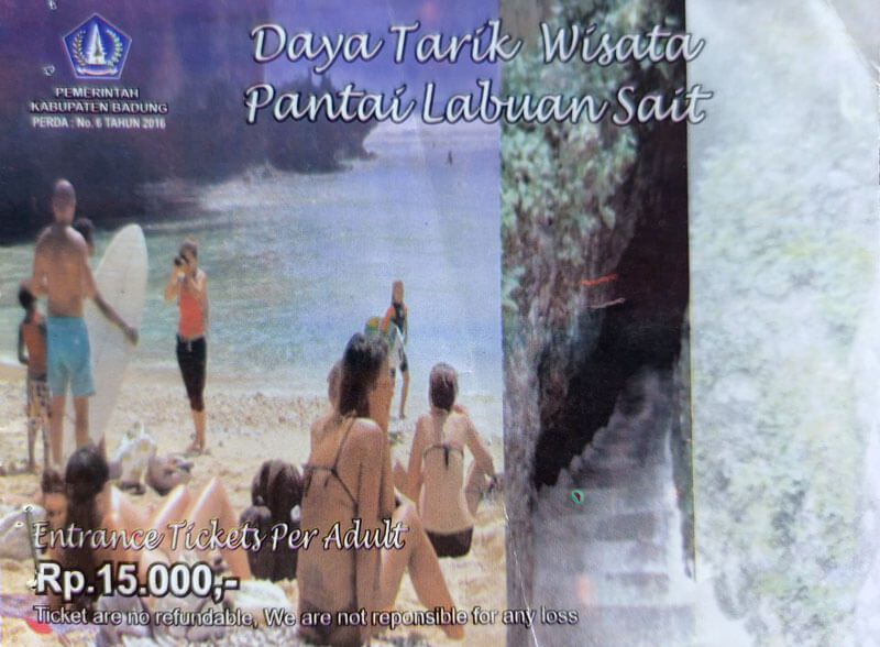 Wisatawan memasuki Pantai Labuan Sait dengan harga tiket masuk tertera di papan informasi