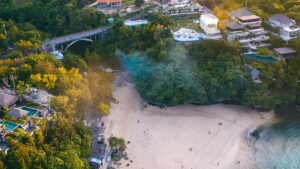 Pemandangan udara Pantai Padang Padang di Bali dengan jembatan dan hutan tropis sekitar