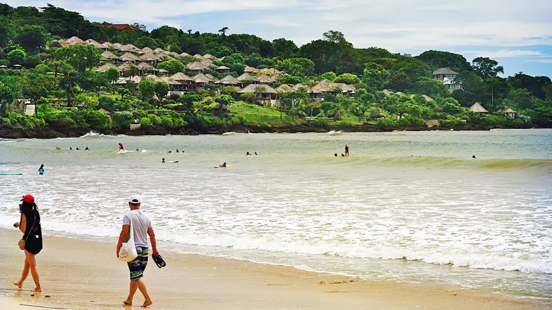 Wisatawan jalan-jalan di tepi Pantai pada sore hari, aktivitas dalam Itinerary Liburan di Jimbaran