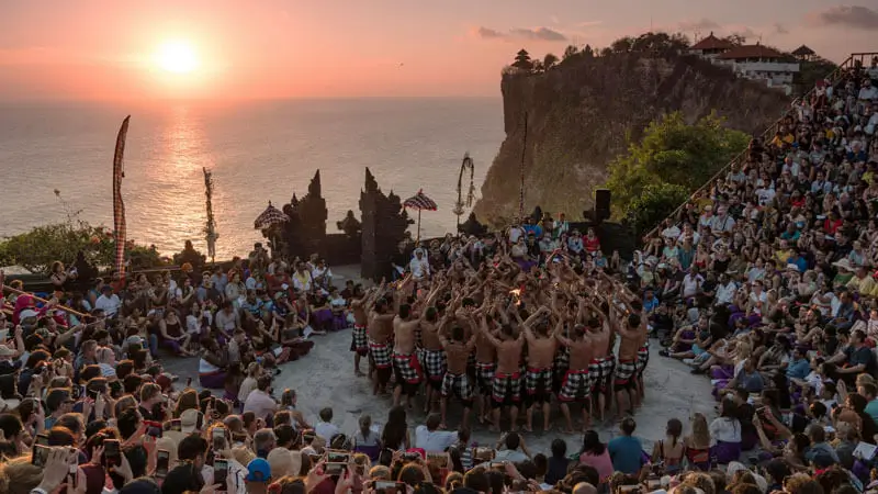 Pura Uluwatu dengan latar belakang matahari terbenam dan pertunjukan Tari Kecak.