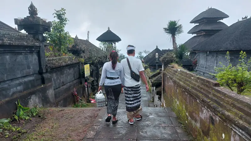 Umat Hindu mengenakan pakaian adat berjalan di kompleks Pura Besakih